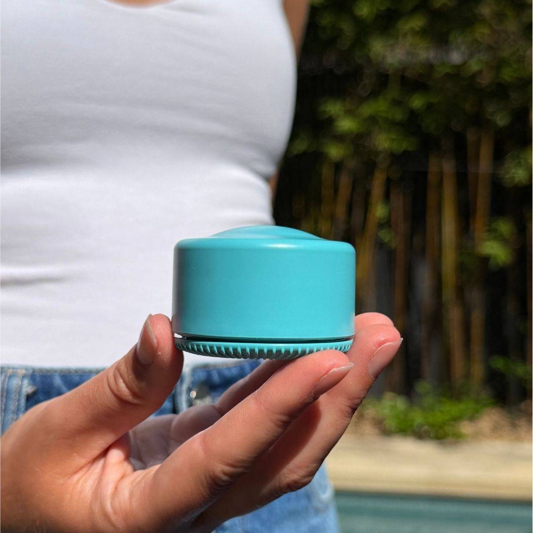 Blue travel refillable pot held in hands